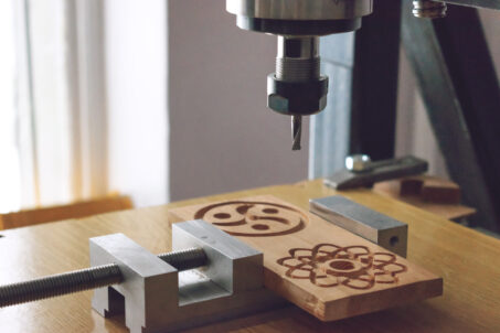 CNC milling machine carving a wooden part blank.