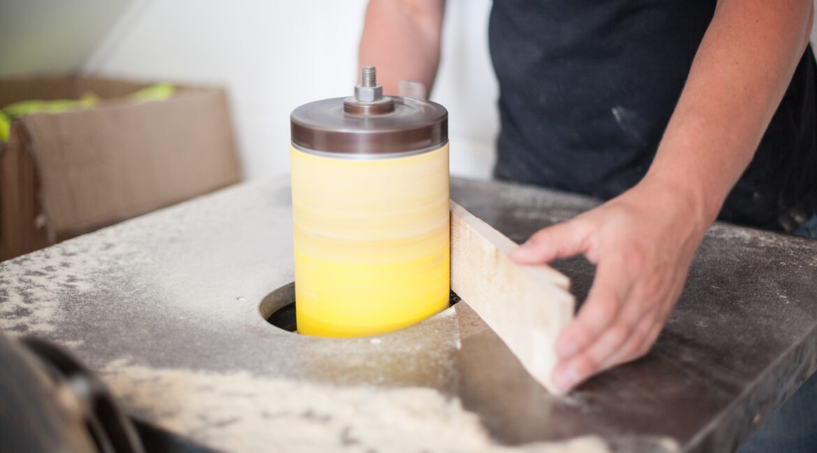 Person sanding wood on a spindle sander