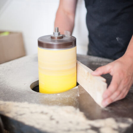 Person sanding wood on a spindle sander