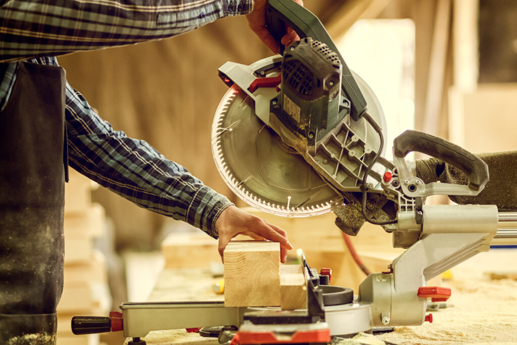 Person cutting wood on a miter saw