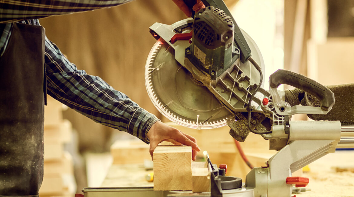 Person cutting wood on a miter saw