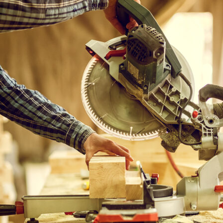Person cutting wood on a miter saw