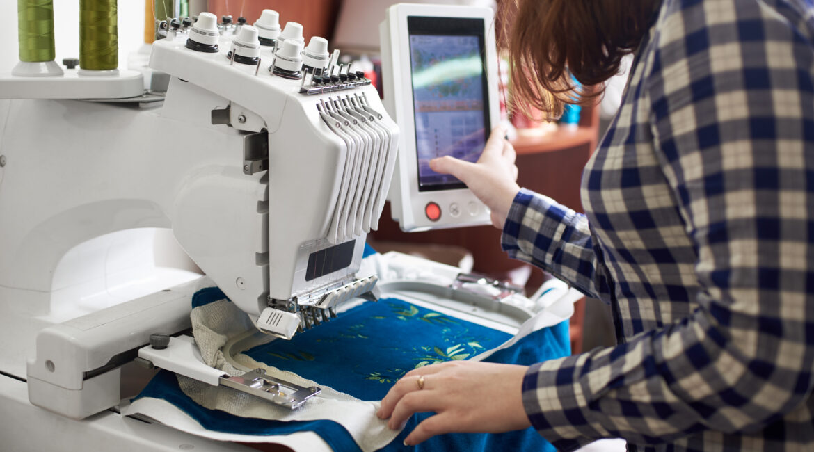 Person programming an embroidery machine