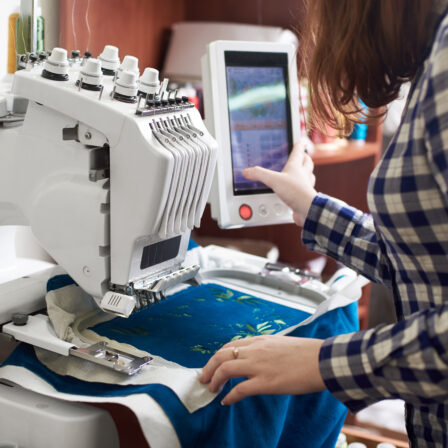 Person programming an embroidery machine