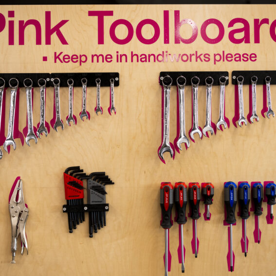 A pink toolboard with hand tools