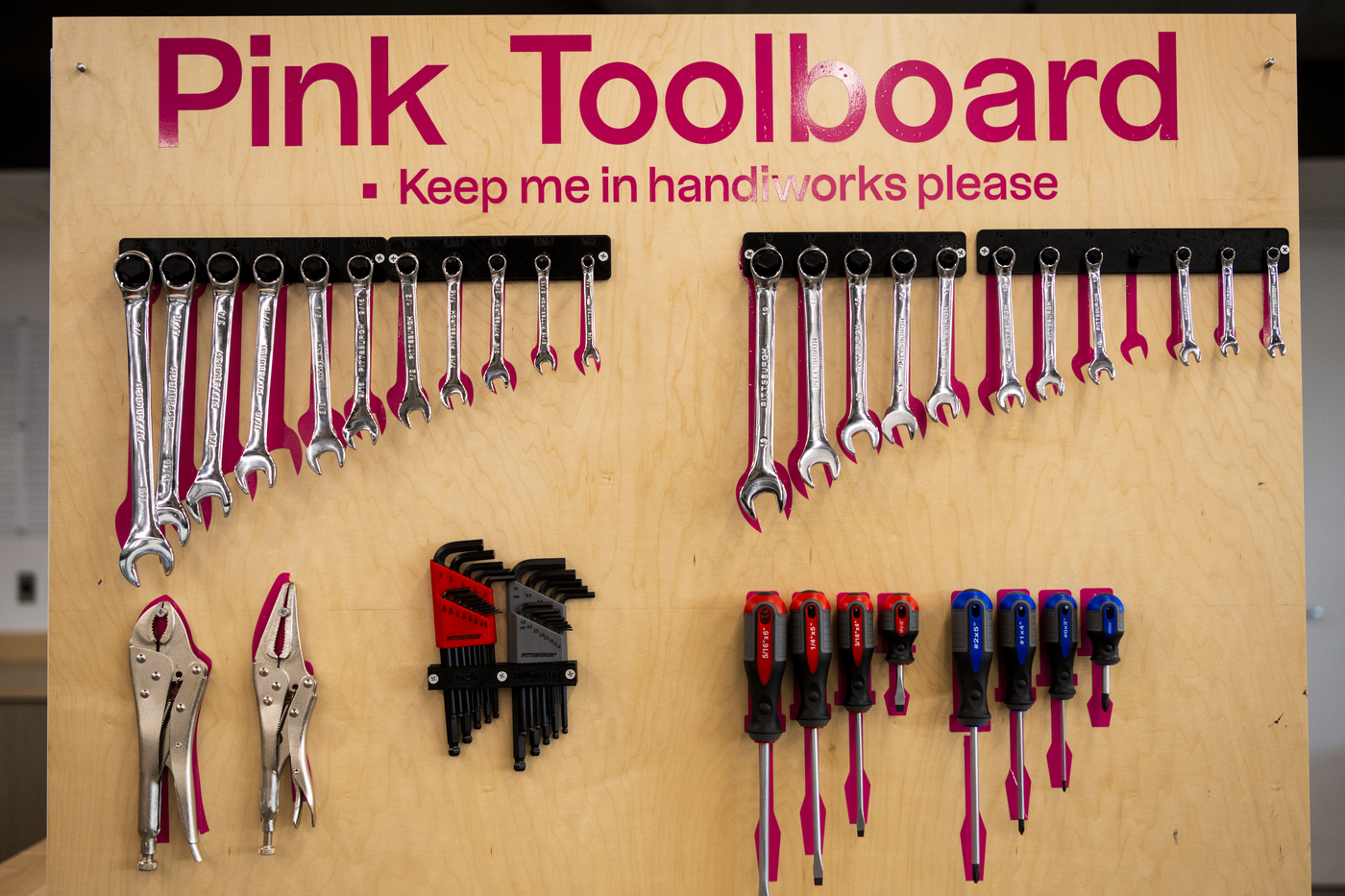 A pink toolboard with hand tools