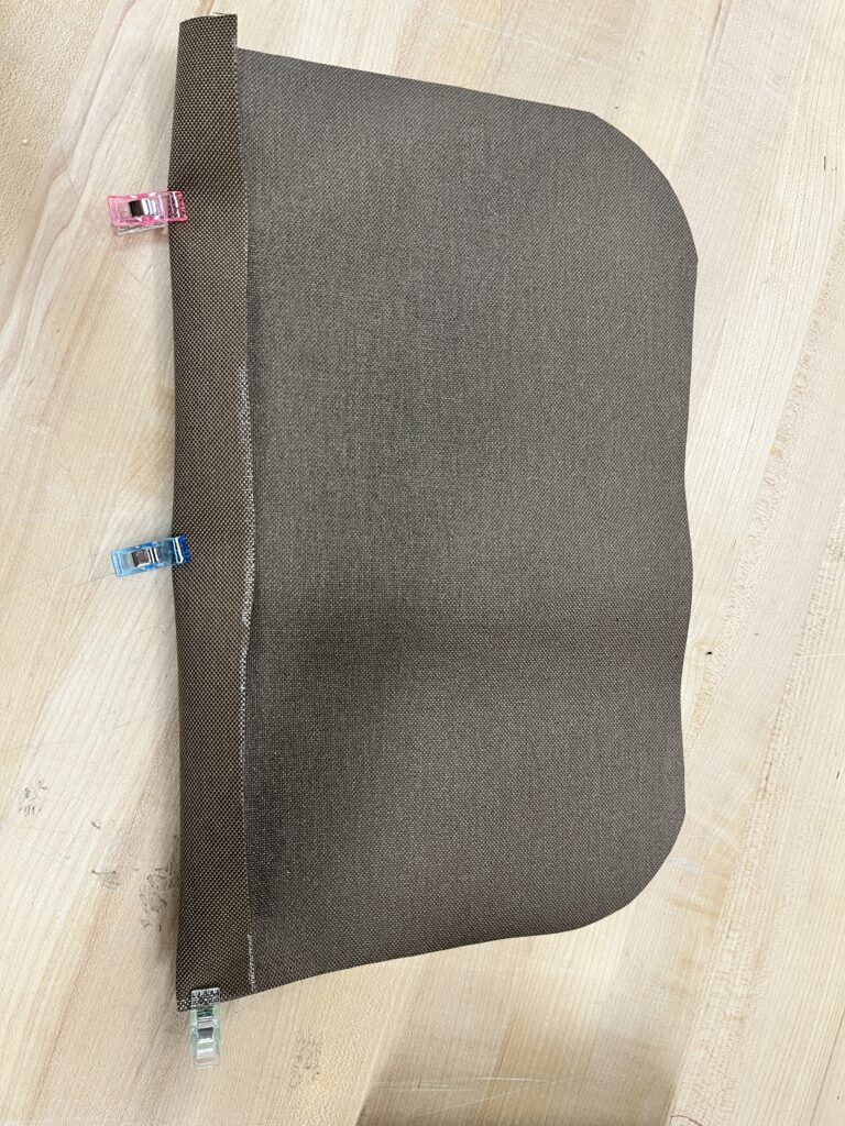 Brown canvas fabric with clips holding it in a fold