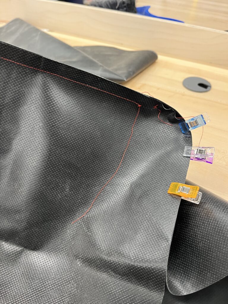 clips and red thread on black tarp