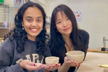 Students hold their ceramics pieces.