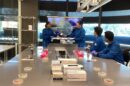 Students in blue lab coats take part in a Microbial Art workshop.