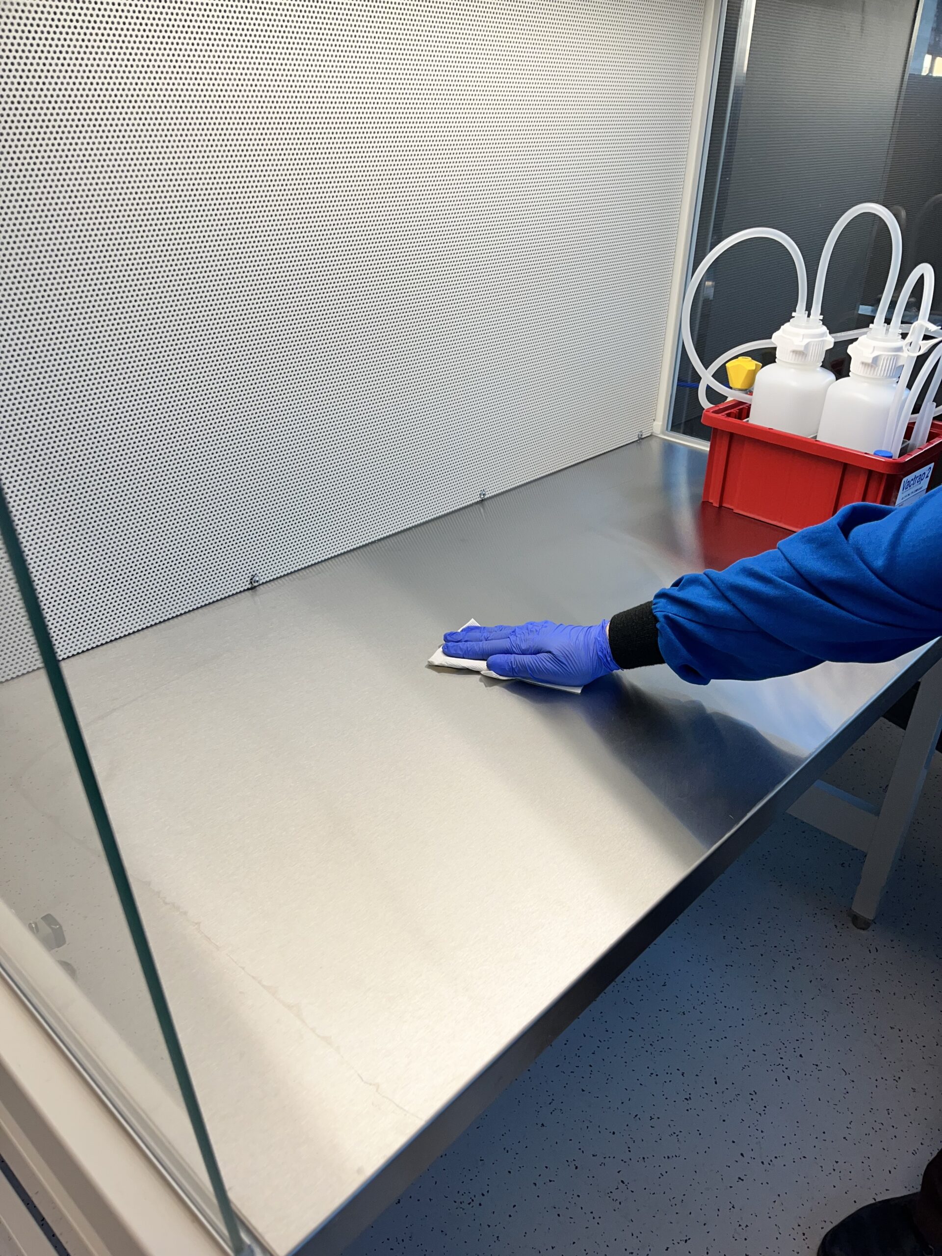 Wiping down the clean bench work surface with disinfectant